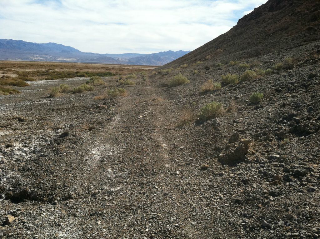 The old closed road continues around the base of the hill: